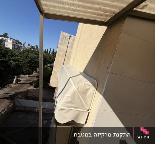 סוכך מרקיזה מתקפל בהיר המותקן על קיר חיצוני